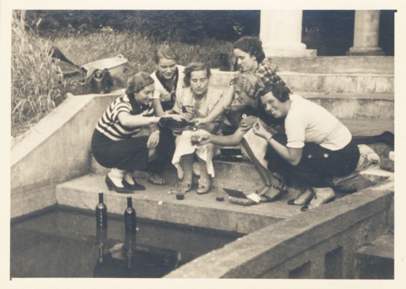Historisches Foto von 6 Frauen, fröhlich sitzend und trinkend auf Steinstufen