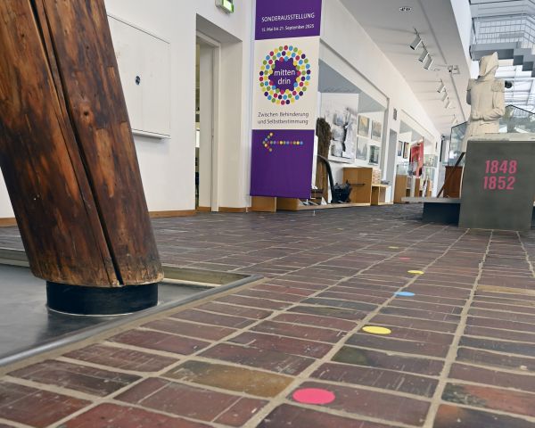 Blich in vom Boden mit Aufklebern zum Saaleingang mit Ausstellungsbanner