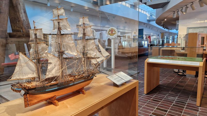 Schiffsmodell eines Segelschiffs mit Blick in die Ausstellung im Erdgeschoss
