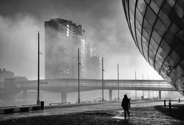 Blick auf Columbus-Hochhäuser mit Glasbrücke, rechts Klimahaus im Anschnitt und Person im Vordergrund