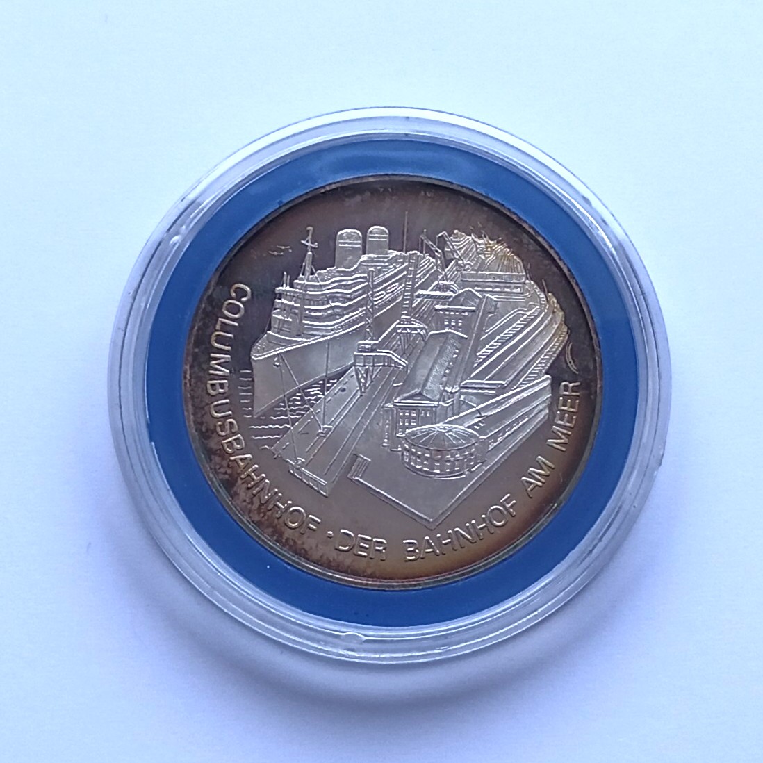 Rückseite einer Medaille zur Numismatika 1981. Abgebildet ist der Columbusbahnhof mit davor liegendem Schiff.