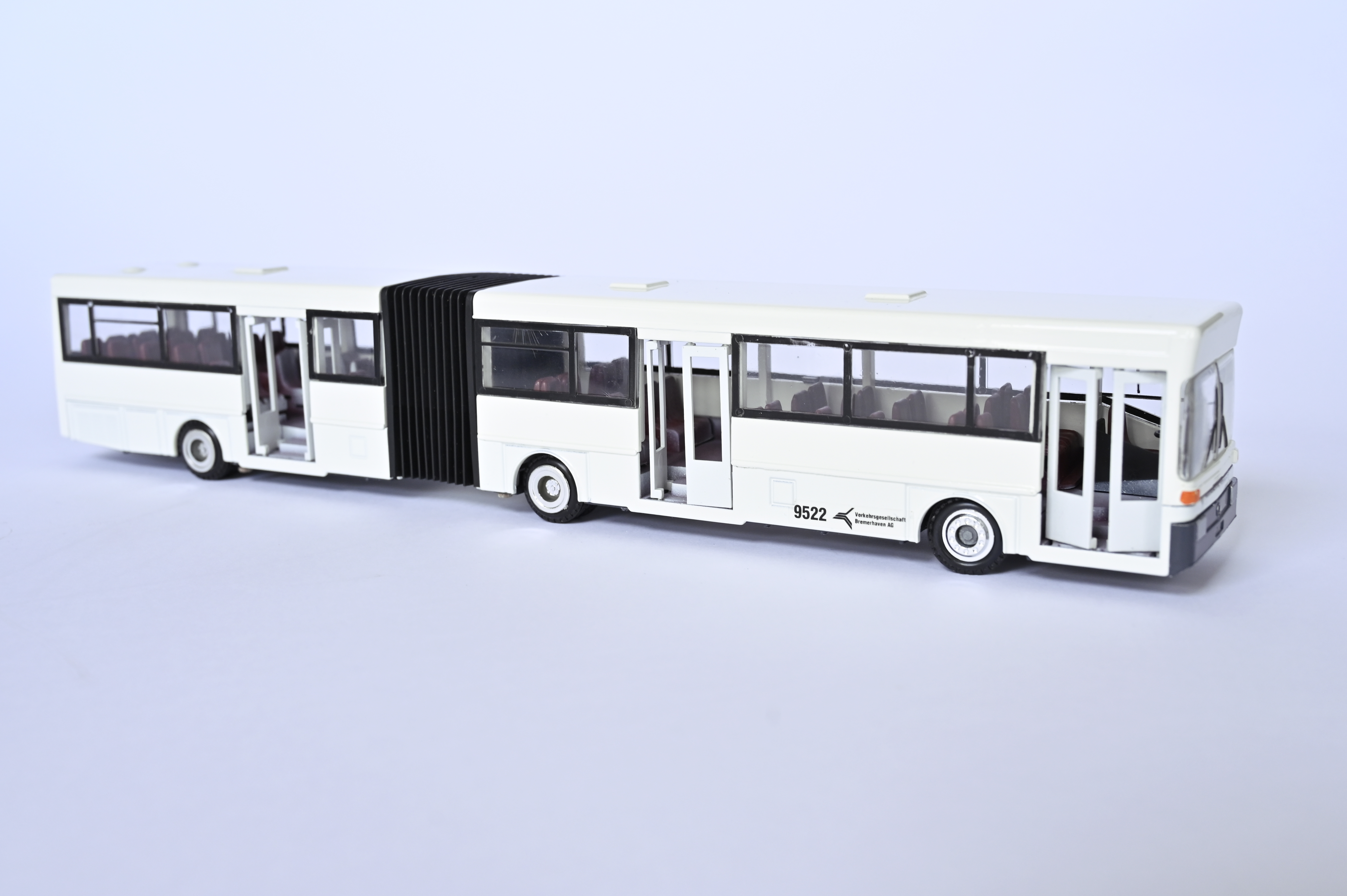 Modell eines weißen Gelenk-Linienbus. Seitliche Aufschrift: 9522 Verkehrsgesellschaft Bremerhaven AG.