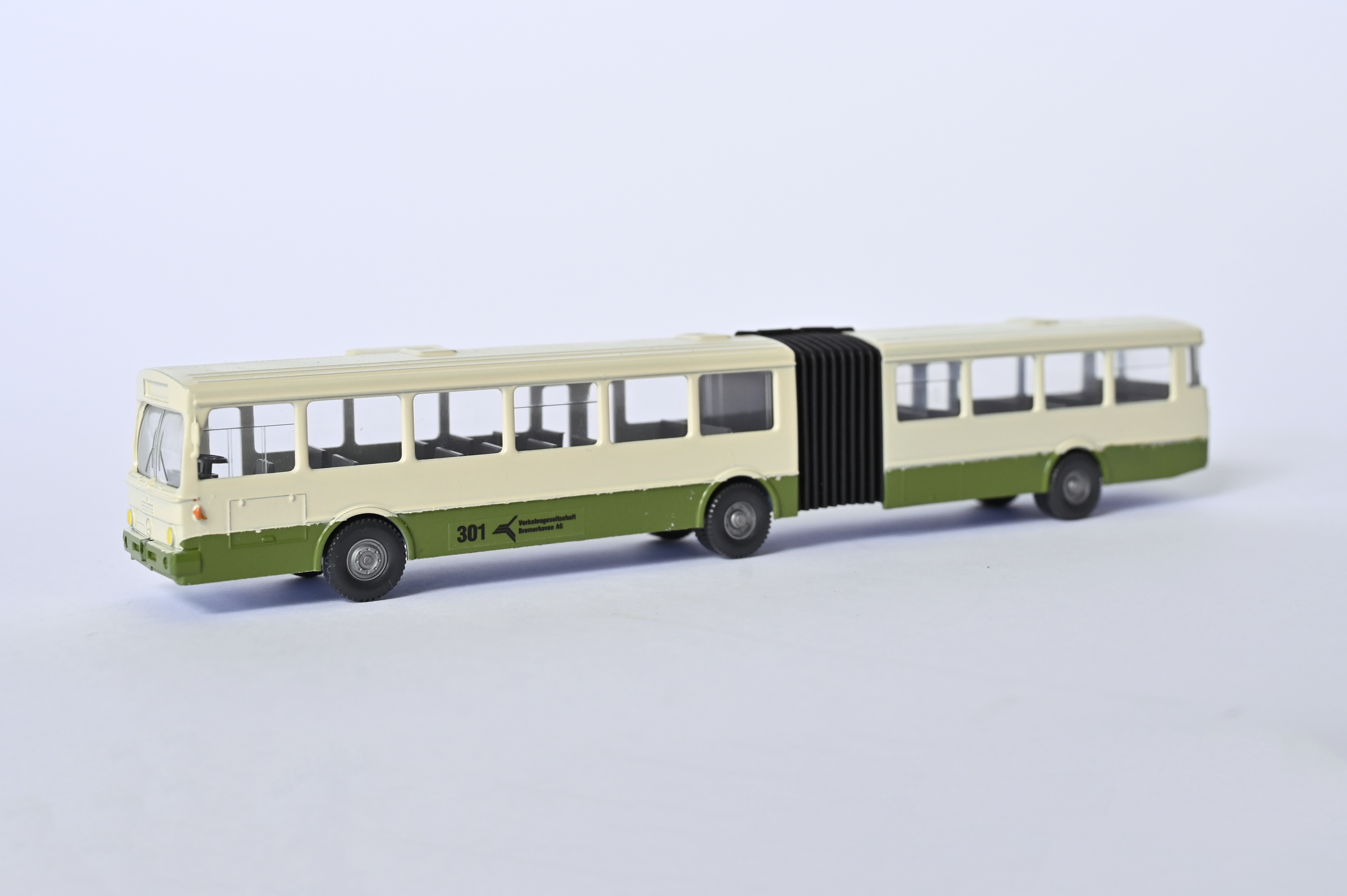 Modell eines grün-weißen Gelenk-Linienbus. Seitliche Aufschrift: 301 Verkehrsgesellschaft Bremerhaven AG.