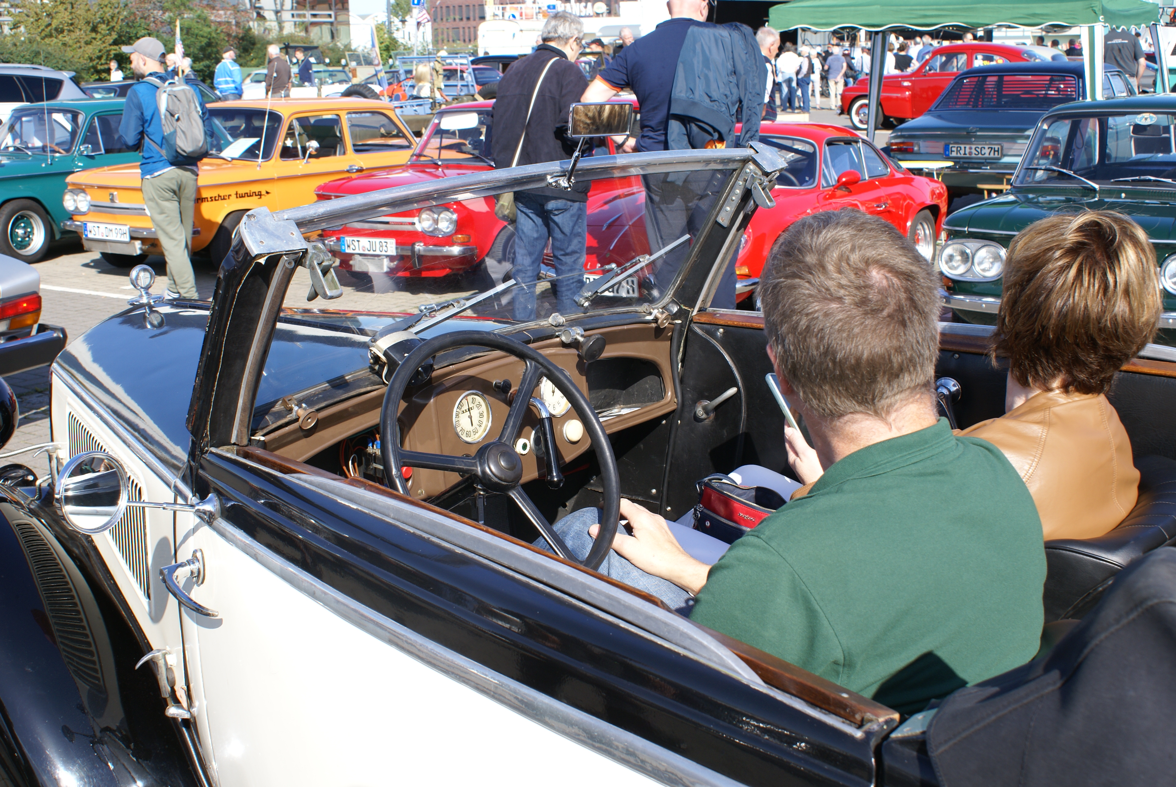 zwei Personen in einem Oldtimer mit offenem Verseck